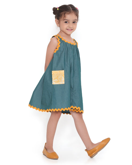 Young girl in a sleeveless Lagoon striped Mangalgiri cotton dress with yellow lace trims and a patch pocket.