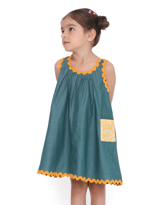 Young girl in a sleeveless Lagoon striped Mangalgiri cotton dress with yellow lace trims and a patch pocket.