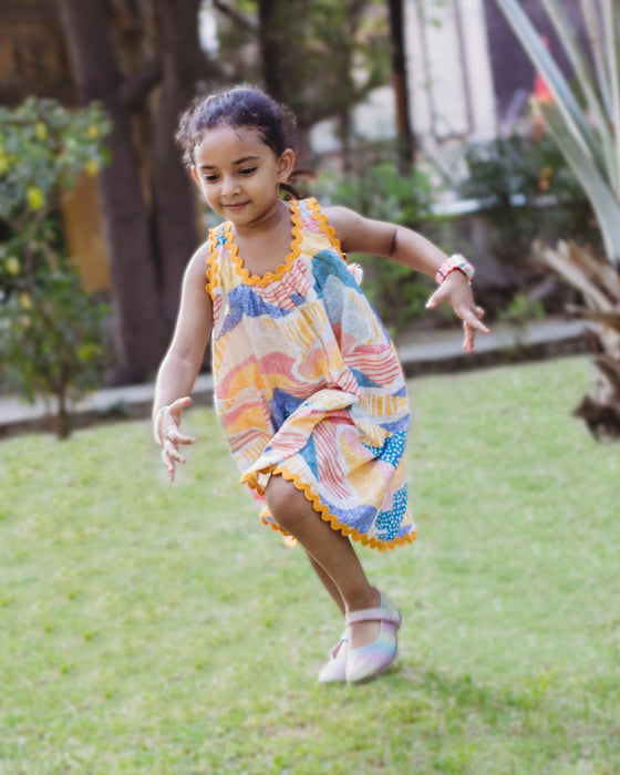 A colourful Whimsy Hills limited edition dress with Schiffli cotton embroidery and yellow lace trim, worn by a young girl