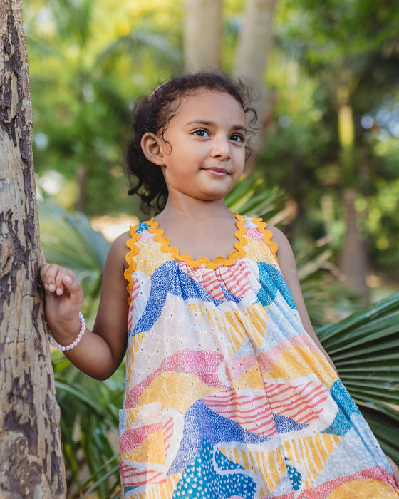 A colourful Whimsy Hills limited edition dress with Schiffli cotton embroidery and yellow lace trim, worn by a young girl