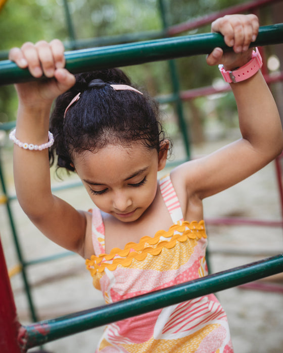 Candy Escape Midi Dress with vibrant pink and yellow hand-drawn print, featuring yellow lace trim, adjustable straps, and plantable tag. Made from 100% natural, hypoallergenic cotton fabric, machine washable for easy care
